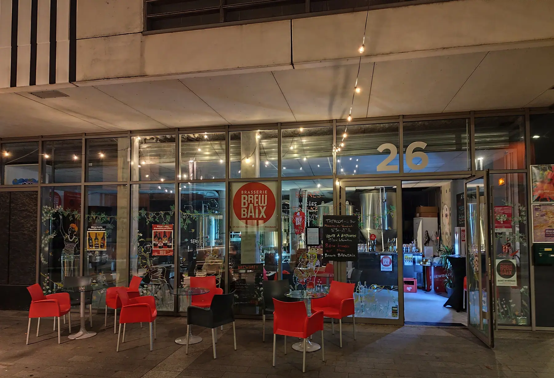 La façade de la taproom Brewbaix éclairée en soirée